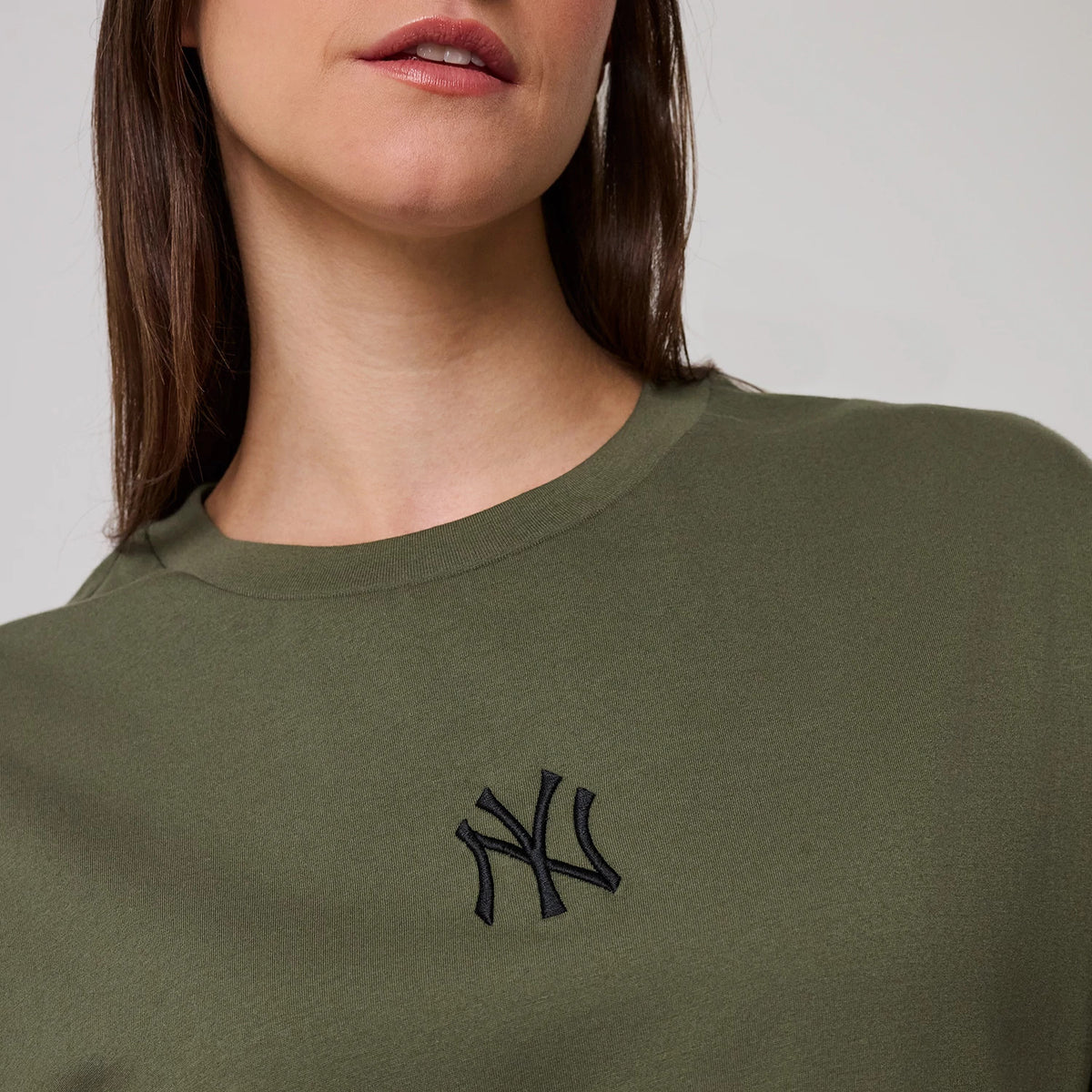 The model is wearing this MLB League Essential New York Yankees Oversized T-Shirt in green. 6