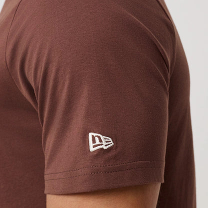 New Era LA Dodgers MLB Linear Brown T-Shirt, side view showing the close-up of the sleeve with an embroidered New Era logo in white near the cuff, highlighting the plain brown fabric and a seam along the arm.