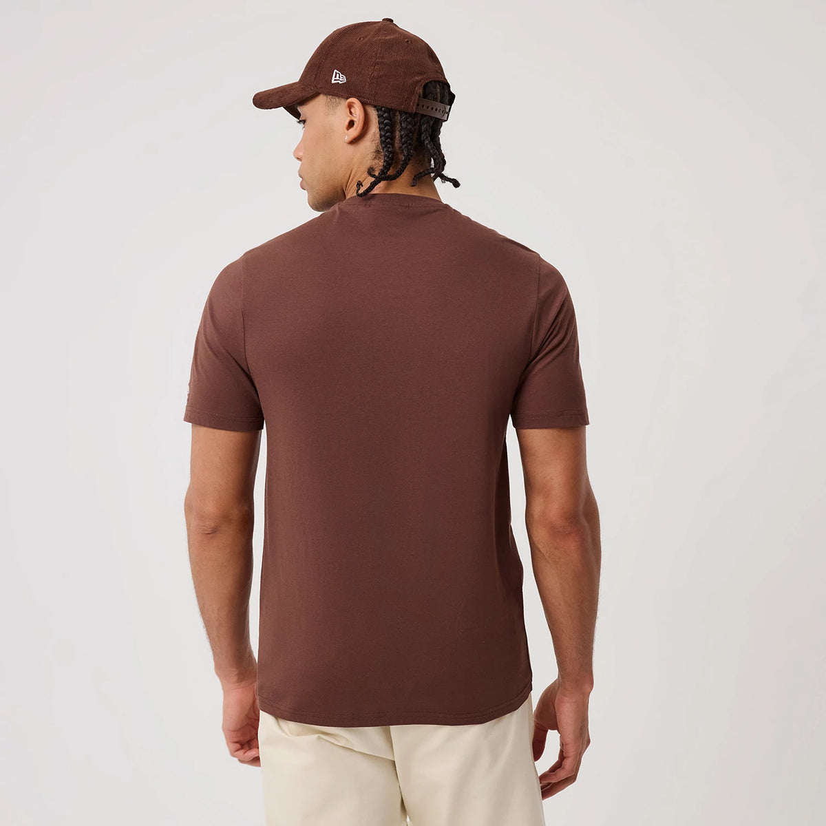 New Era LA Dodgers MLB Linear Brown T-Shirt, back view on a model wearing a similar brown cap, showing the plain brown back with short sleeves and a neat round neckline, creating a minimalistic and casual aesthetic.