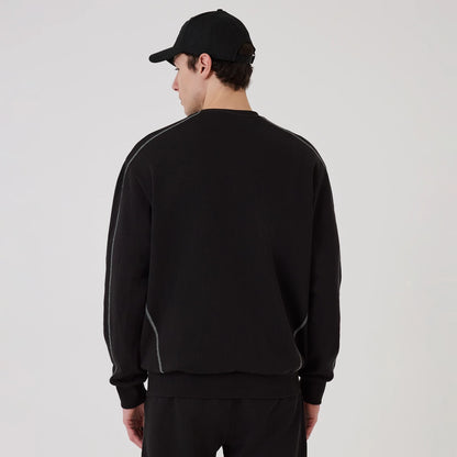 New Era Chicago Bulls NBA Graphic Black Crew Neck Sweater, back view on a model wearing a black cap, showing the sweater's black fabric with grey piping along the shoulders and side seams, and a relaxed fit at the hem and cuffs.