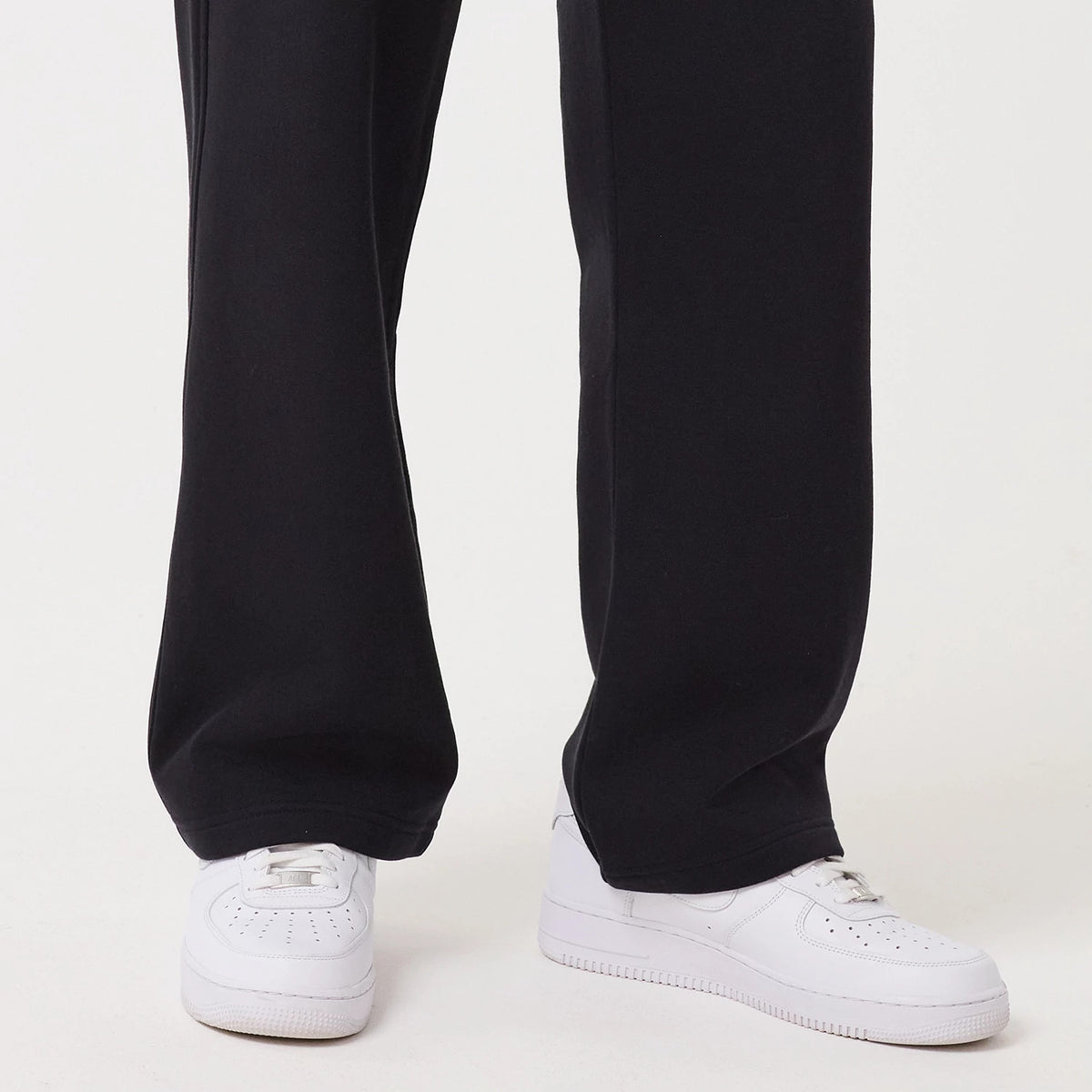 New Era Navy Straight Leg Joggers, close-up view showing the relaxed fit around the ankles, deep navy colour and the pairing with white trainers, highlighting the fabric texture and simple hem design.