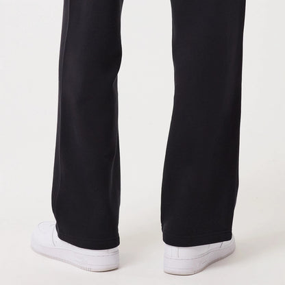 New Era Navy Straight Leg Joggers, rear view on a model showing the relaxed fit around the calves and ankles, with clean hems resting over white trainers, highlighting the navy fabric and straight-leg silhouette.