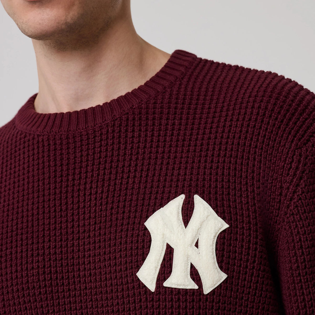The model is wearing this MLB Waffle Knit New York Yankees Crew Neck Sweater in dark purple. 5