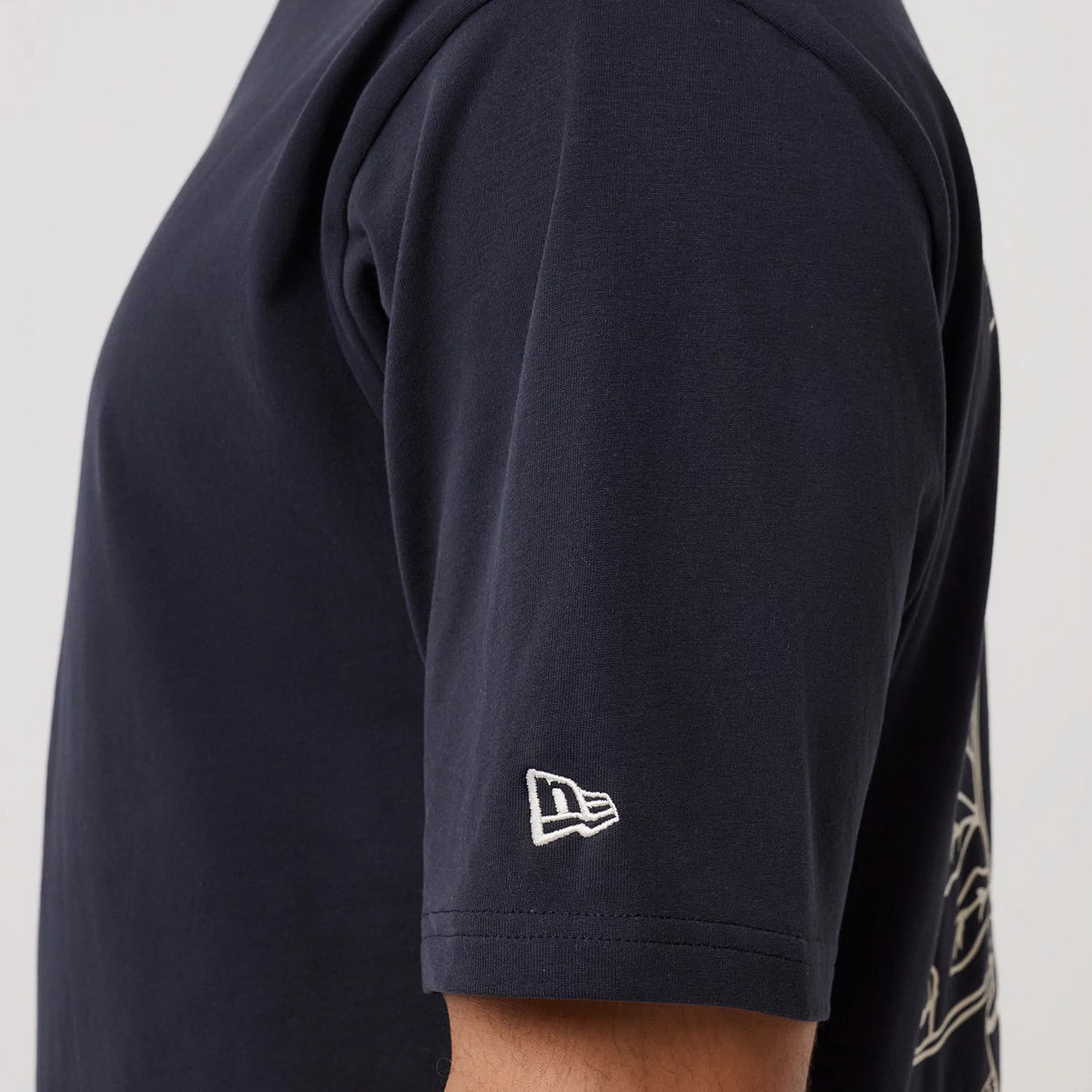 The model is wearing this New Era Crest Graphic Oversized T-Shirt in navy. 7