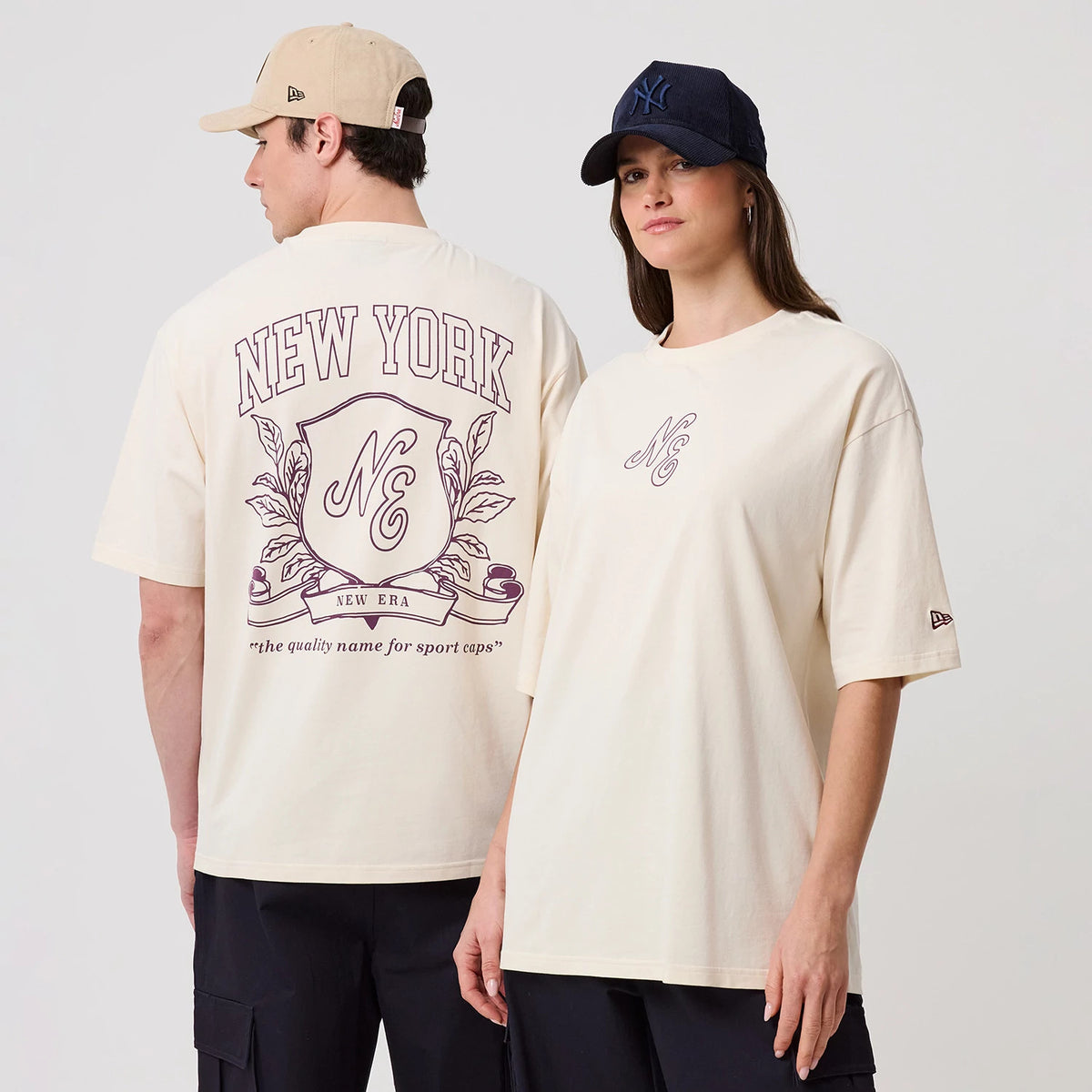New Era Crest Graphic Open White Oversized T-Shirt, front and back view on models showing a large crest design with New York lettering on the back and a small NC logo on the front, both featuring embroidered New Era logos on the sleeves.
