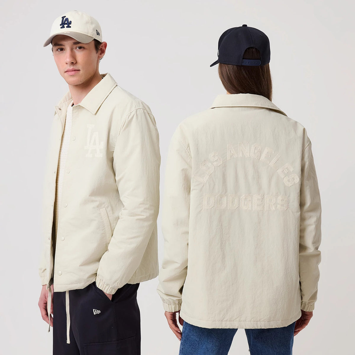 New Era LA Dodgers MLB Light Beige Coach Jacket, front and back view on models showing the embroidered LA logo on the front left chest, snap button closure, and Los Angeles Dodgers lettering across the upper back, with fitted cuffs and side pockets.