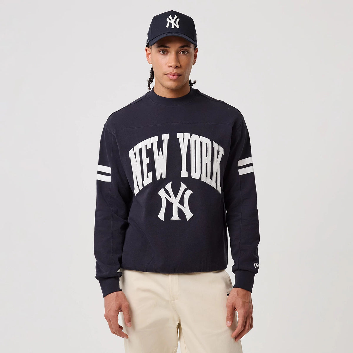 The model is wearing this MLB Arch Graphic New York Yankees Crew Neck Sweater in navy. 3
