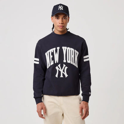 The model is wearing this MLB Arch Graphic New York Yankees Crew Neck Sweater in navy. 3