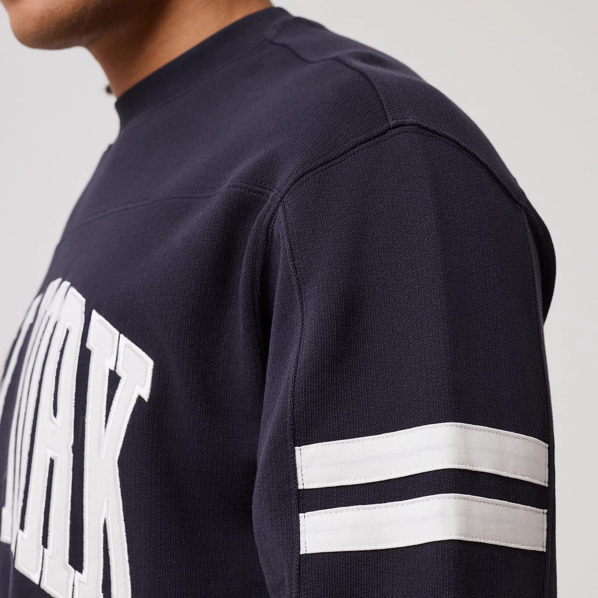 The model is wearing this MLB Arch Graphic New York Yankees Crew Neck Sweater in navy. 8