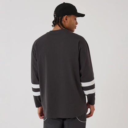 The model is wearing this MLB League Essential New York Yankees Oversized Jersey in charcoal. 2