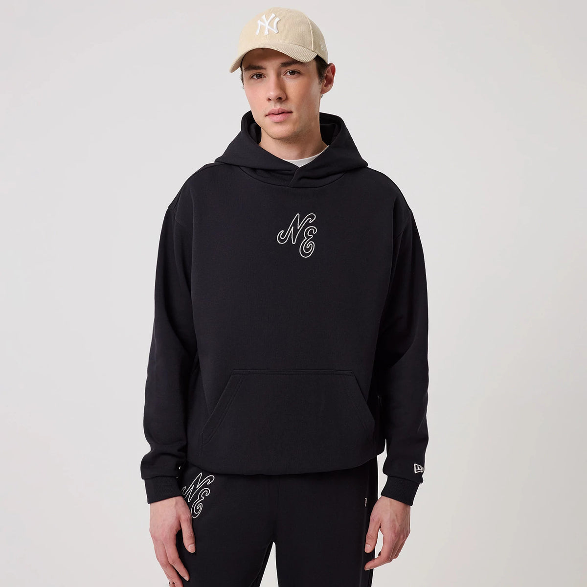 The model is wearing this New Era Crest Graphic Pullover Hoodie in navy. 3