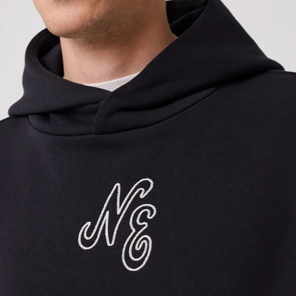 The model is wearing this New Era Crest Graphic Pullover Hoodie in navy. 5