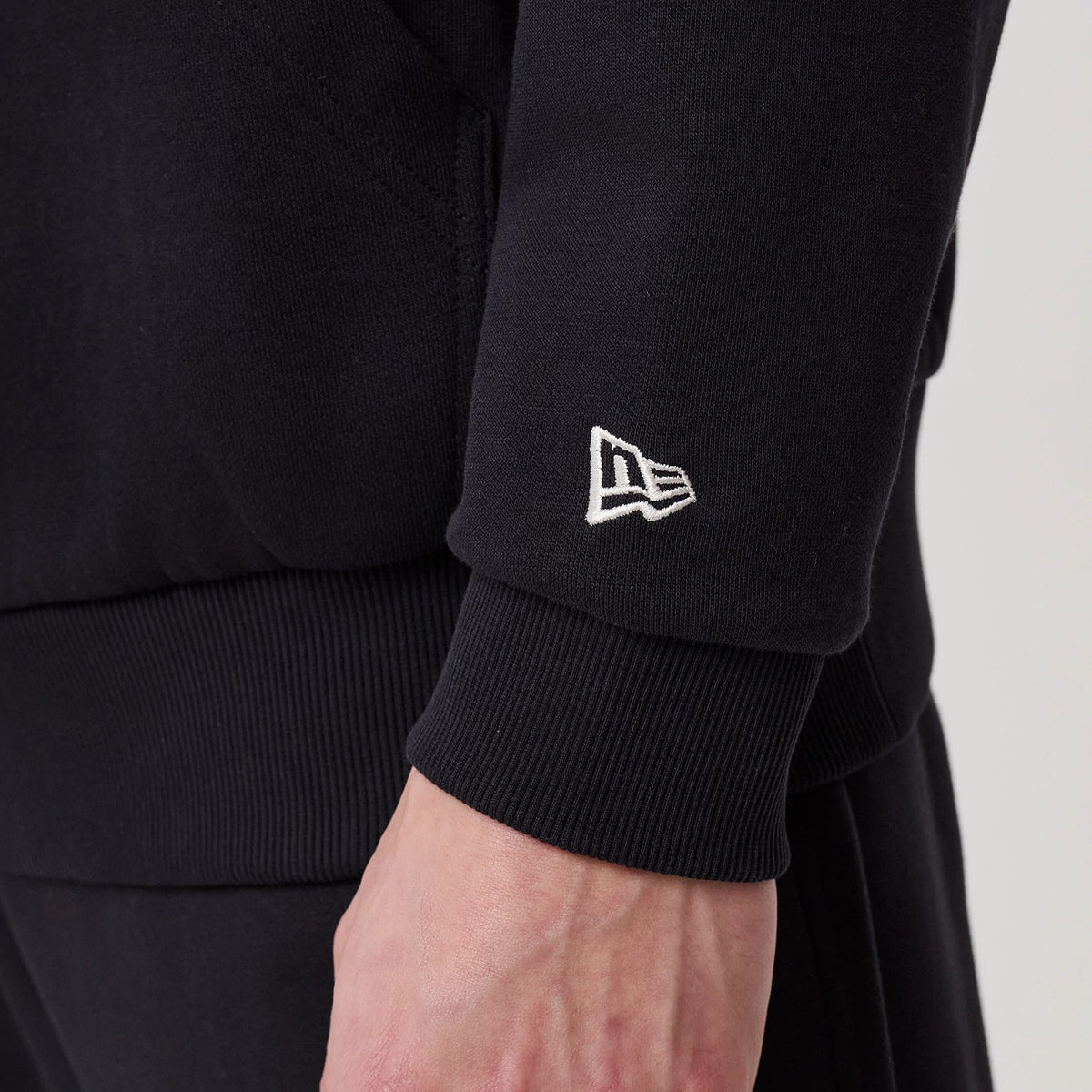 The model is wearing this New Era Crest Graphic Pullover Hoodie in navy. 7