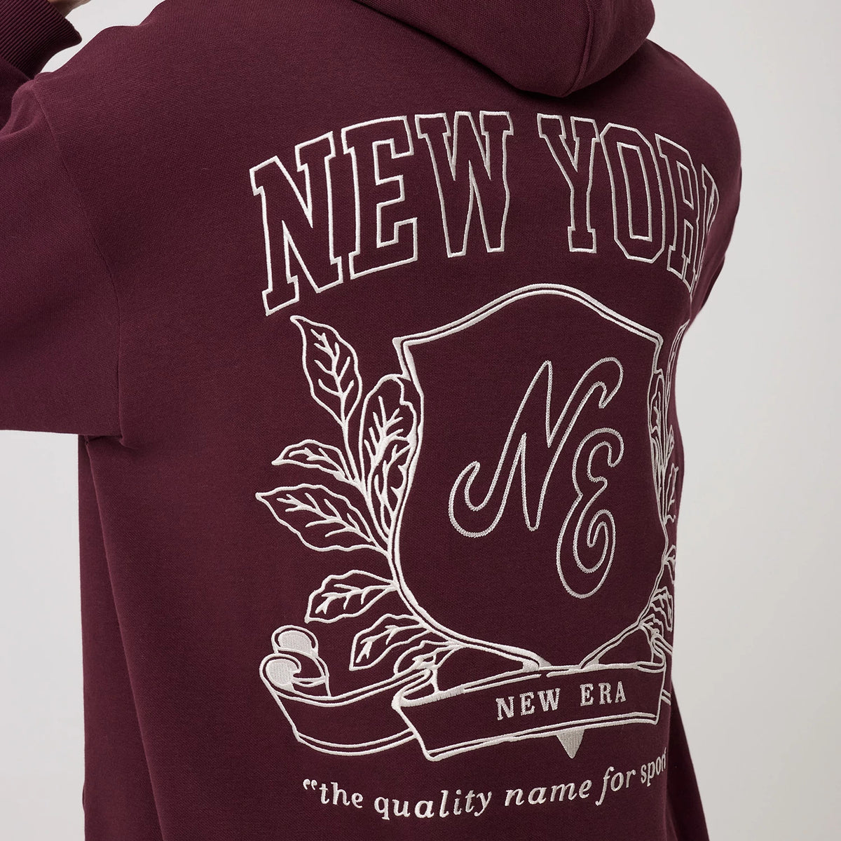 The model is wearing this New Era Crest Graphic Pullover Hoodie in dark purple. 8