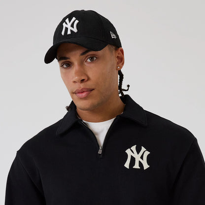 The model is wearing this MLB New York Yankees 1/4 Zip Sweater in black. 4