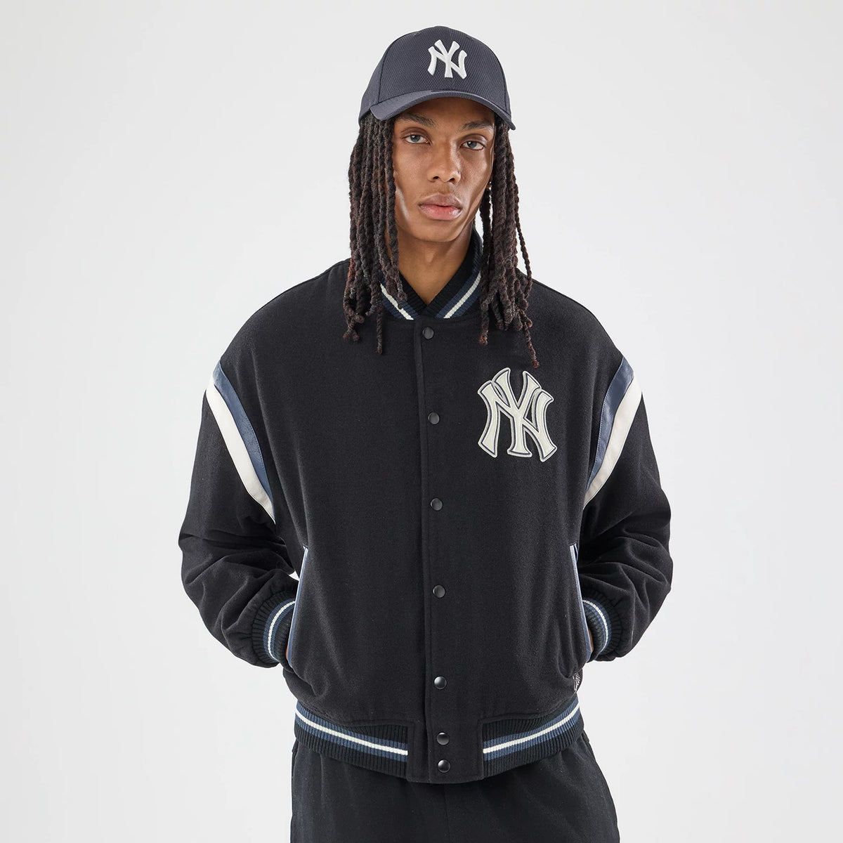 The model is wearing this MLB New York Yankees Varsity Jacket in black. 1