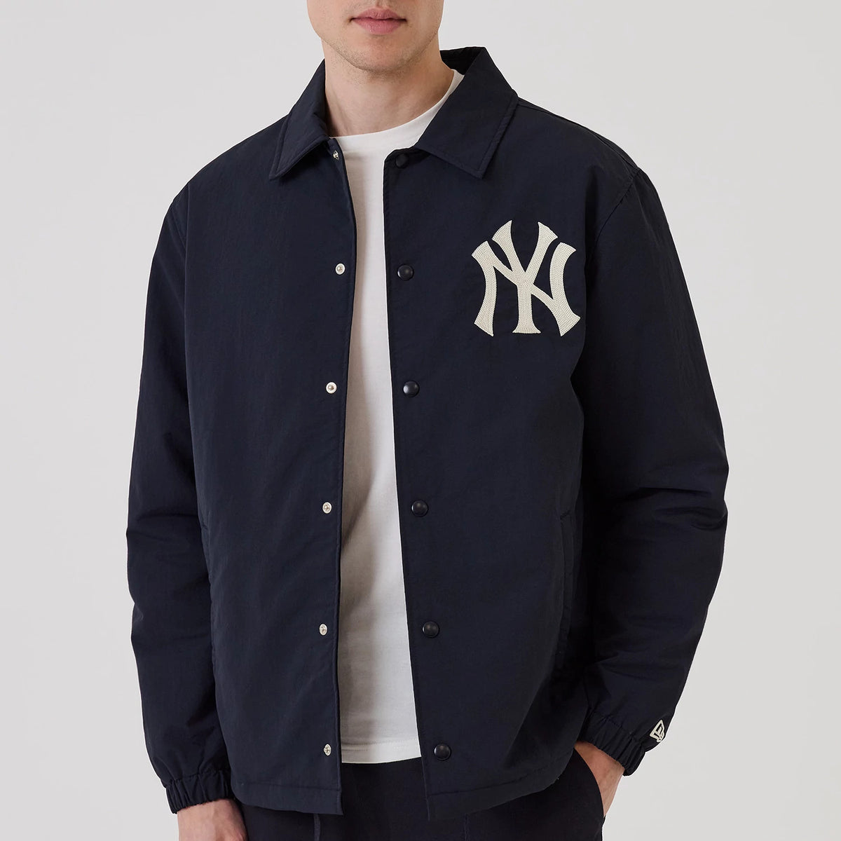 The model is wearing this MLB New York Yankees Coach Jacket in navy. 3