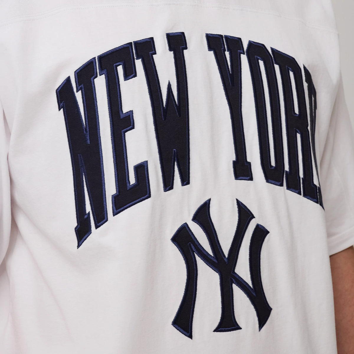 The model is wearing this MLB Arch Graphic New York Yankees Oversized T-Shirt in white. 5