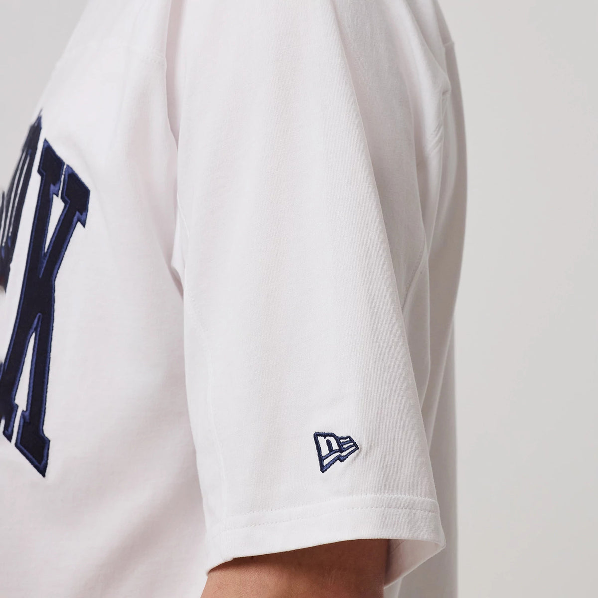 The model is wearing this MLB Arch Graphic New York Yankees Oversized T-Shirt in white. 7