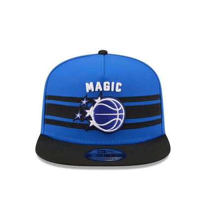 Orlando Magic NBA Tip Off 2026 Blue New Era 9FIFTY A-Frame Snapback Adjustable Cap, front view showing the raised embroidered Magic basketball and stars logo in white and blue on the front panel, with a black flat visor and 9FIFTY size sticker.