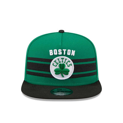 Boston Celtics NBA Tip Off 2026 Green New Era 9FIFTY A-Frame Snapback Adjustable Cap, front view showing a raised white Boston embroidery and a central Celtics logo with a green shamrock, black stripes across the green crown.