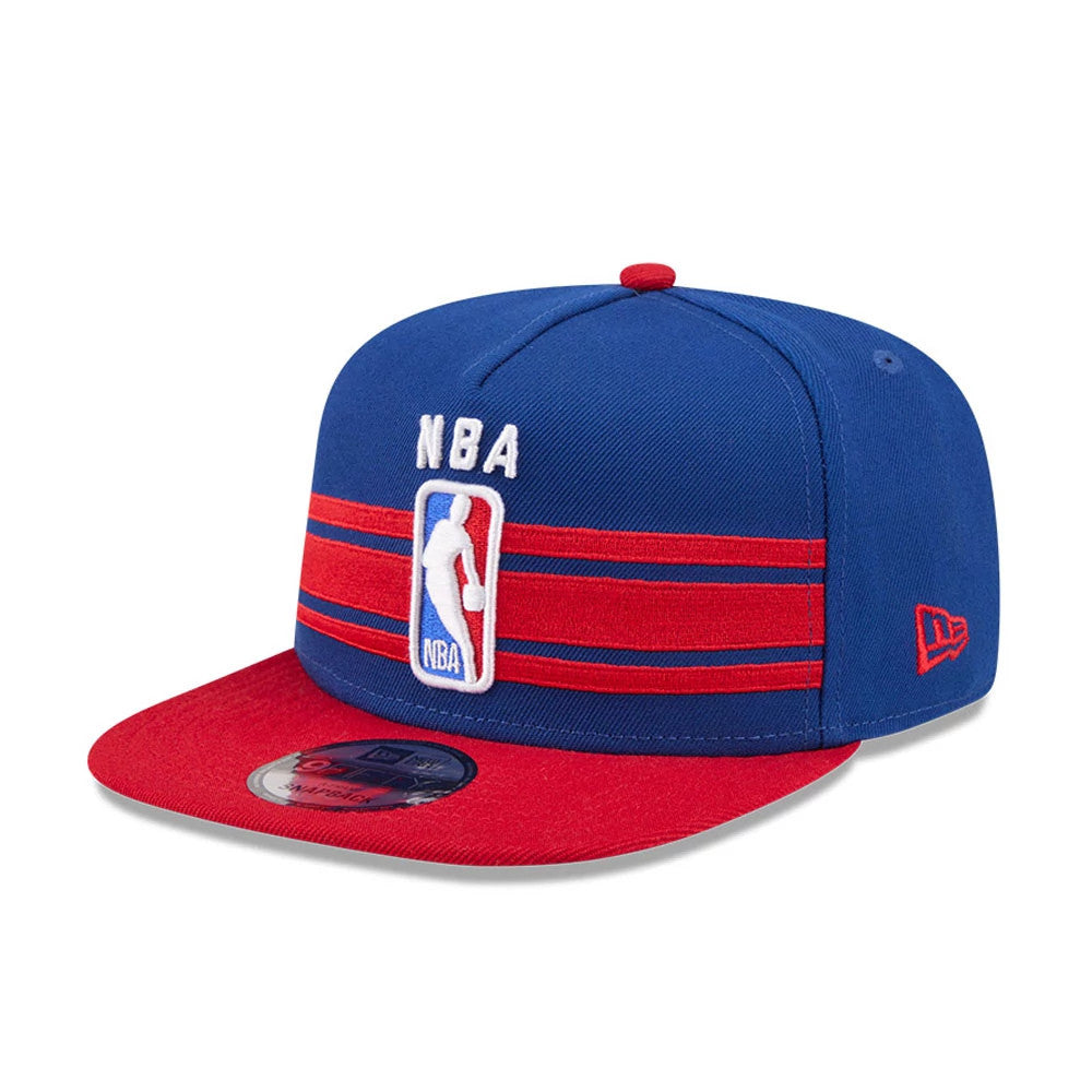 NBA Logo NBA Tip Off 2026 Blue New Era 9FIFTY A-Frame Snapback Adjustable Cap, three-quarter view showing the raised embroidered NBA logo in white on the blue front panel, featuring red and blue striped bands and red undervisor.
