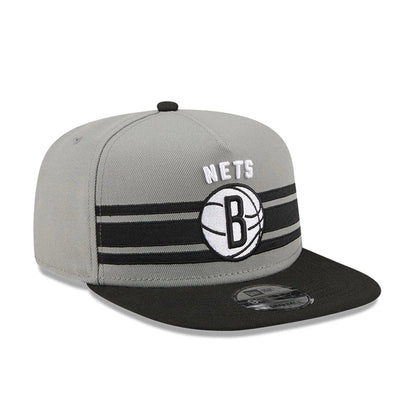 Brooklyn Nets NBA Tip Off 2026 Dark Grey New Era 9FIFTY A-Frame Snapback Adjustable Cap, front view showing raised white embroidered Nets and black B basketball logo on grey crown, with a black visor and a 9FIFTY size sticker.