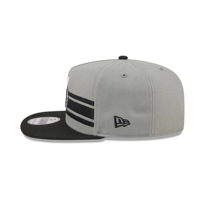 Brooklyn Nets NBA Tip Off 2026 Dark Grey New Era 9FIFTY A-Frame Snapback Adjustable Cap, side view showing the New Era flag logo on the grey crown, with black parallel stripes, and a flat black visor with a grey 9FIFTY size sticker.