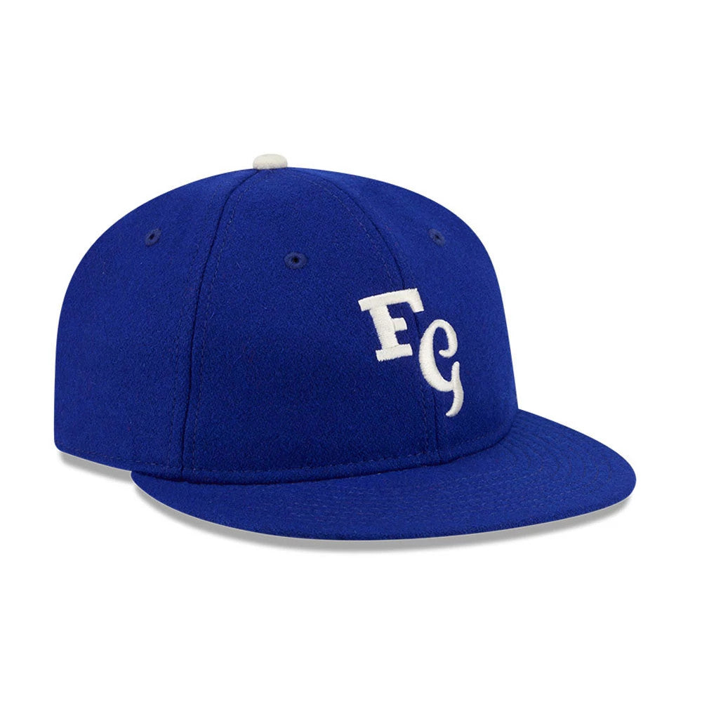 LA Dodgers Fear Of God X MLB Open Blue Retro Crown New Era 59FIFTY Fitted Cap, three-quarter view showing the white raised embroidered FG logo on the structured blue crown, with blue flat visor, blue eyelets and white top button.