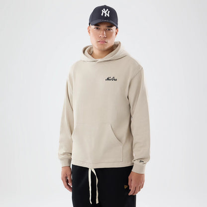 The model is wearing this New Era Open Hem Pullover Hoodie in light beige. 1
