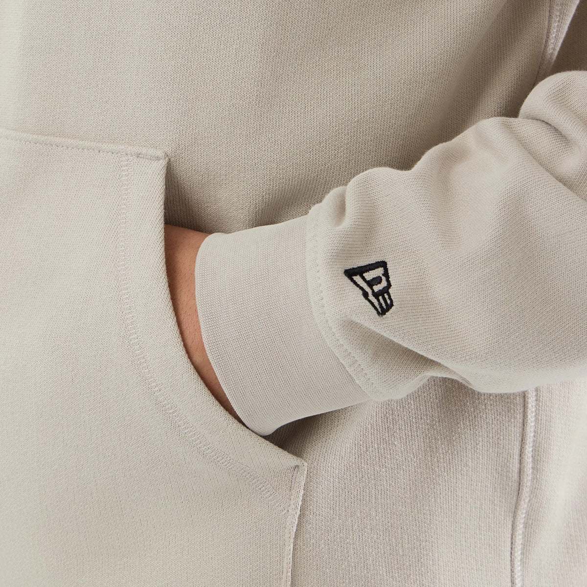 The model is wearing this New Era Open Hem Pullover Hoodie in light beige. 4