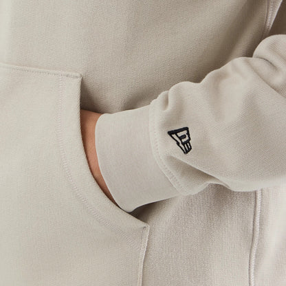 The model is wearing this New Era Open Hem Pullover Hoodie in light beige. 4