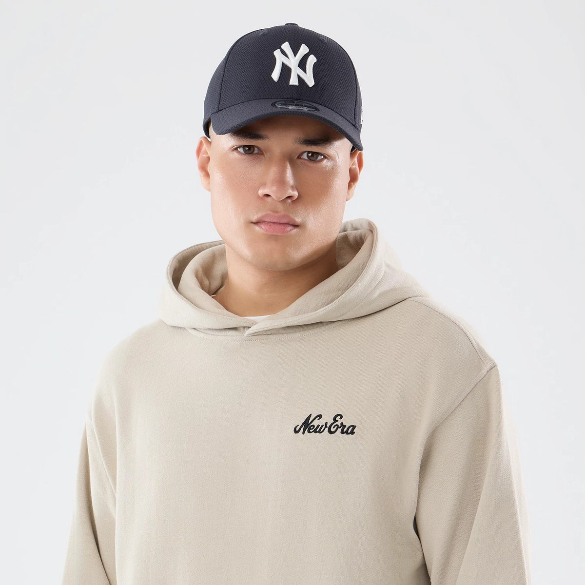 The model is wearing this New Era Open Hem Pullover Hoodie in light beige. 5
