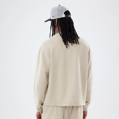 The model is wearing this New Era Open Hem Oversized Crew Neck Sweater in light beige. 2
