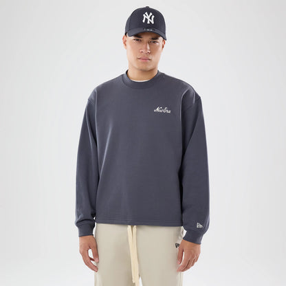 The model is wearing this New Era Open Hem Oversized Crew Neck Sweater in dark grey. 1