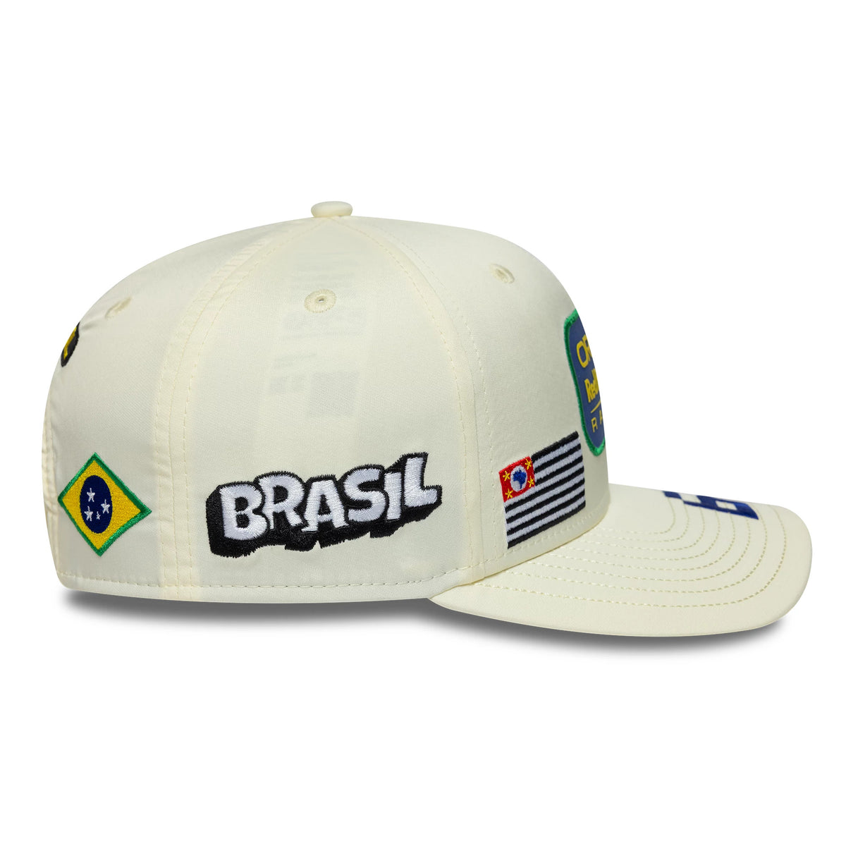 Red Bull Racing Brazil Race Special Isack Hadjar Cream New Era 9SEVENTY Stretch Snap Adjustable Cap, side view showing Brazil flag and embroidered BRASIL text on the cream crown, with a flat black and white striped design beside it.