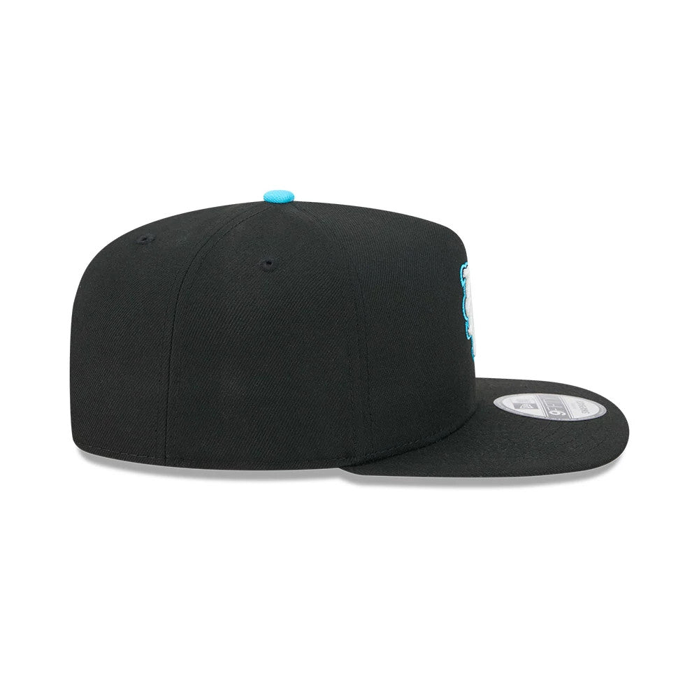 Mets MLB Electrocute Black New Era 9FIFTY A-Frame Snapback Adjustable Cap, side view showing the light blue New Era flag logo on the left side, a black structured crown, and a contrasting turquoise top button with a flat black visor.