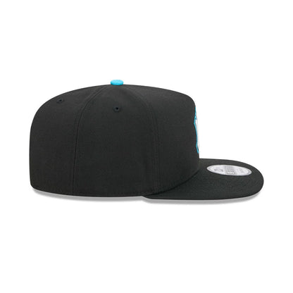 Yankees MLB Electrocute Black New Era 9FIFTY A-Frame Snapback Adjustable Cap, side view showing the flat black visor, an aqua top button matching the side logo embroidery peeking from the right front panel, and a 9FIFTY size sticker on the visor.