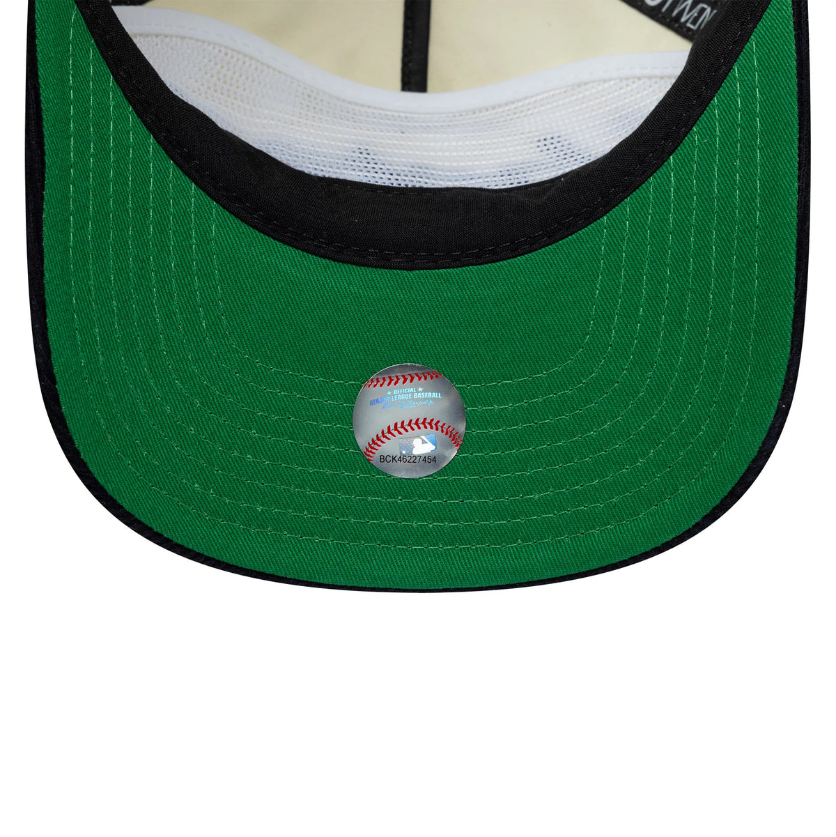 New York Yankees MLB Retro Dynasty Cream & Navy New Era 19TWENTY Adjustable Cap, inside view showing a green undervisor with white stitching, a black sweatband, and a circular baseball sticker at the centre near the edge.