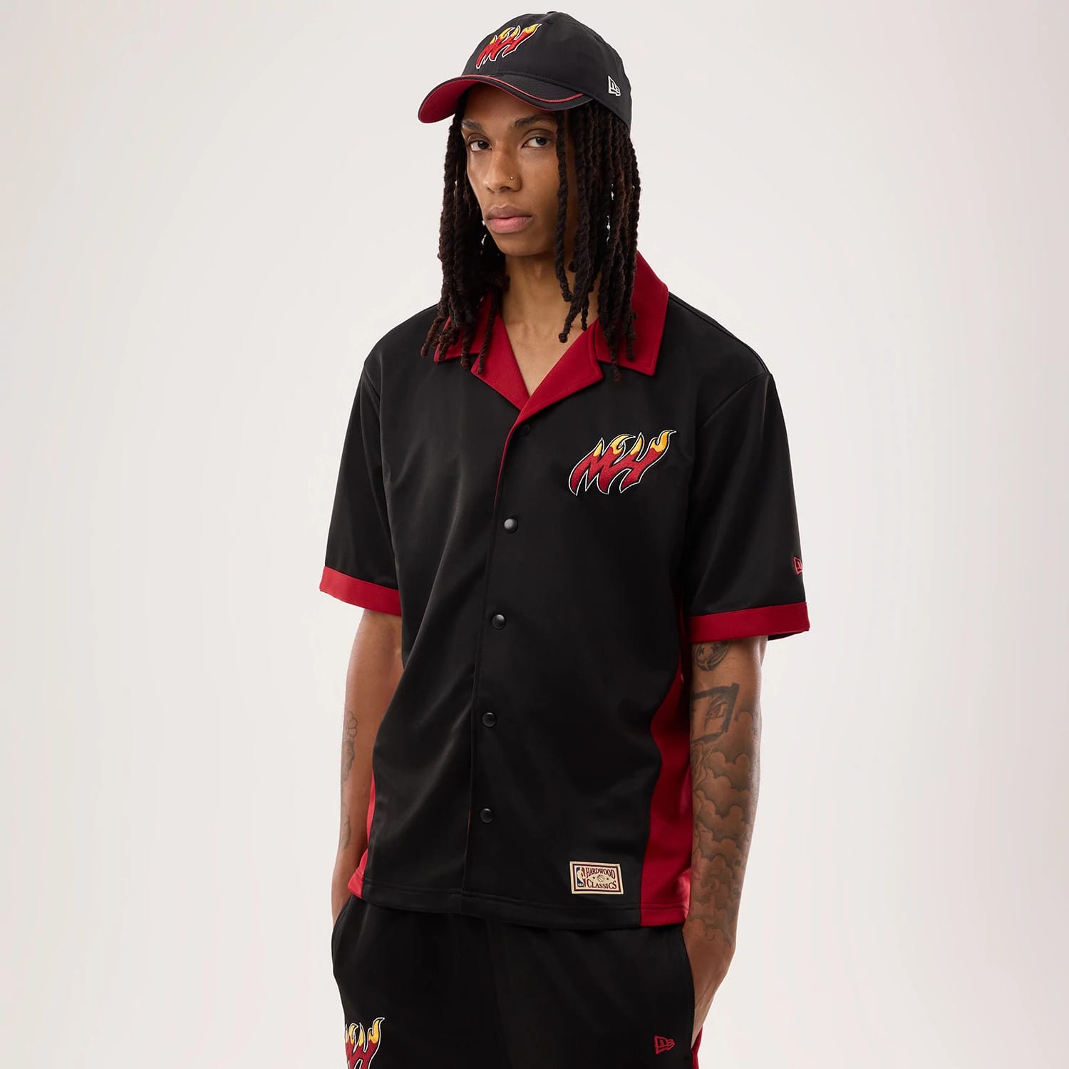 The model is wearing this NBA Hardwood Classic Revere Miami Heat Short Sleeve Shirt in black. 1