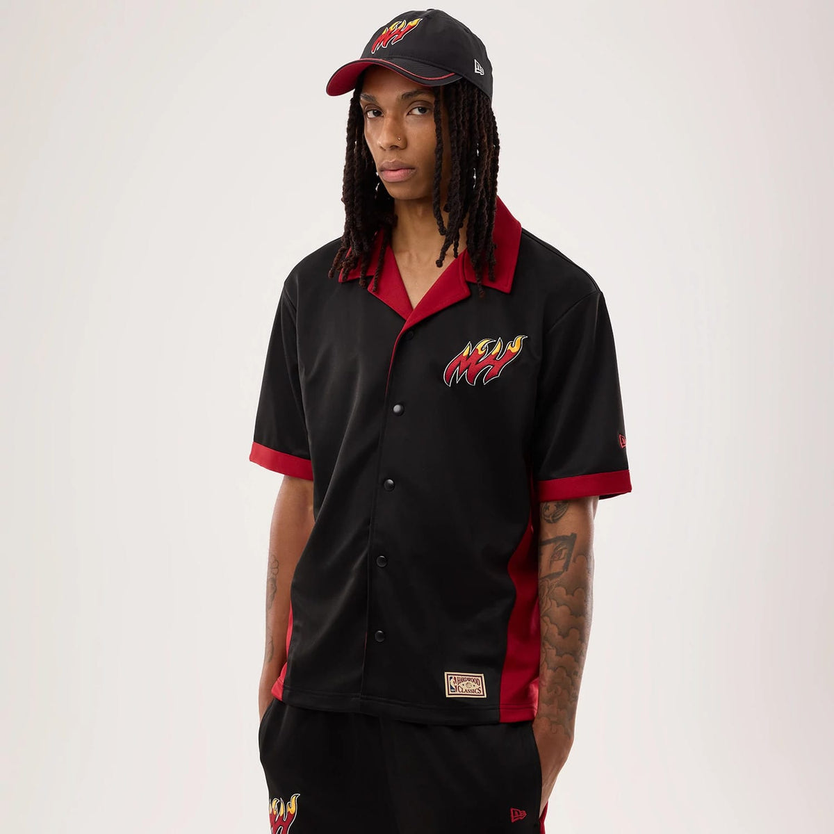 The model is wearing this NBA Hardwood Classic Revere Miami Heat Short Sleeve Shirt in black. 1