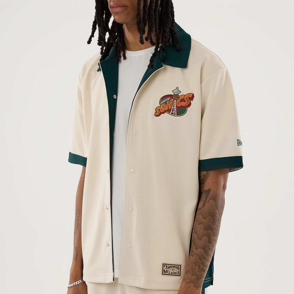 The model is wearing this NBA Hardwood Classic Revere Seattle Supersonics Short Sleeve Shirt in light beige. 4