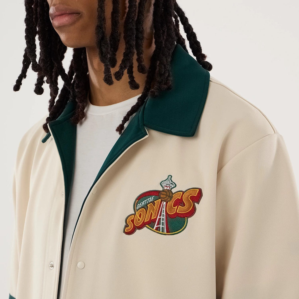 The model is wearing this NBA Hardwood Classic Revere Seattle Supersonics Short Sleeve Shirt in light beige. 5