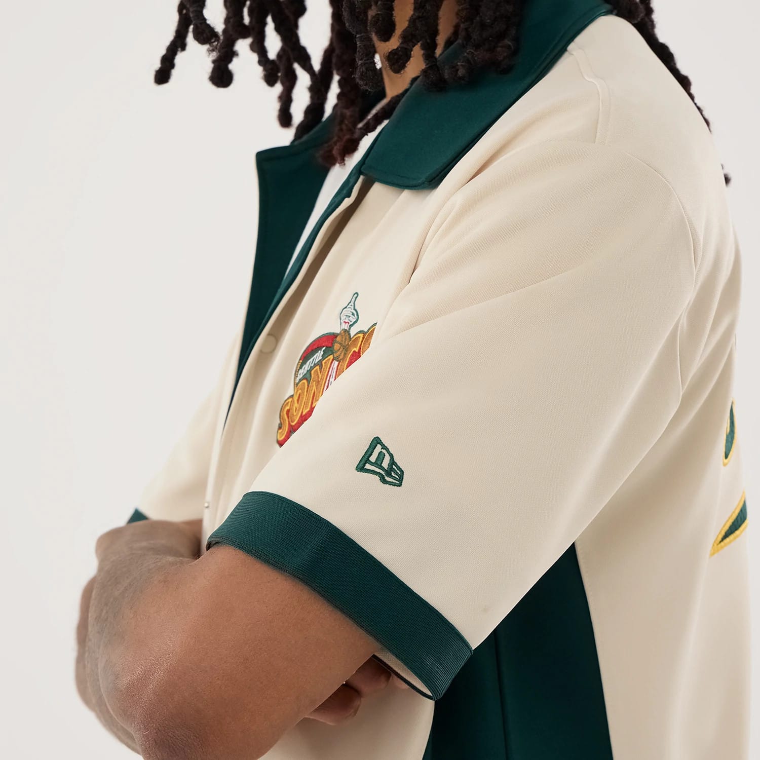 The model is wearing this NBA Hardwood Classic Revere Seattle Supersonics Short Sleeve Shirt in light beige. 3