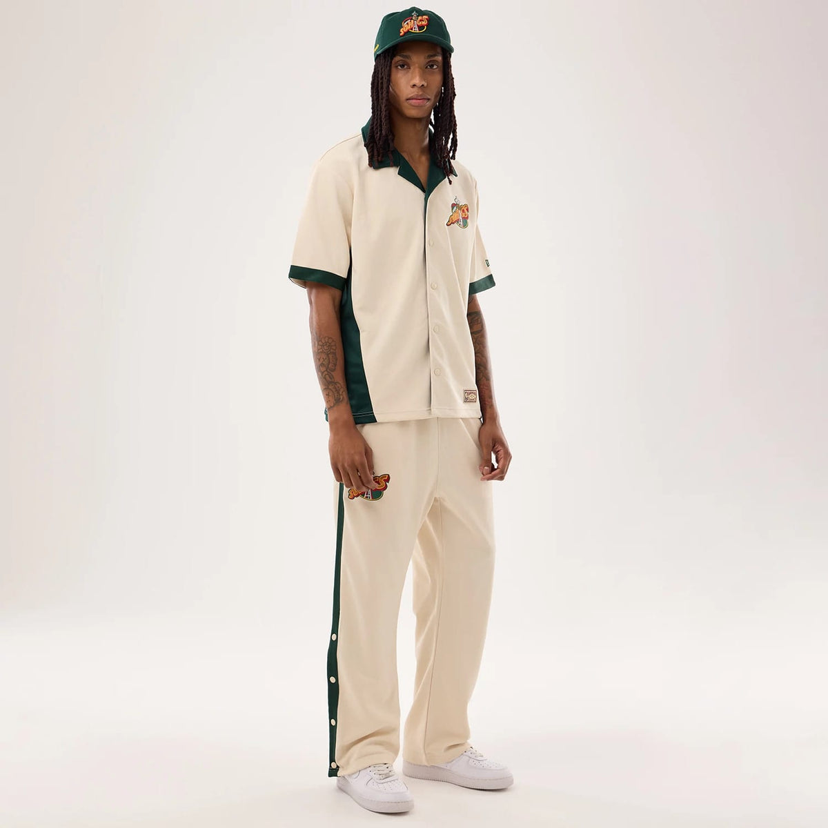 The model is wearing this NBA Hardwood Classic Revere Seattle Supersonics Short Sleeve Shirt in light beige. 8
