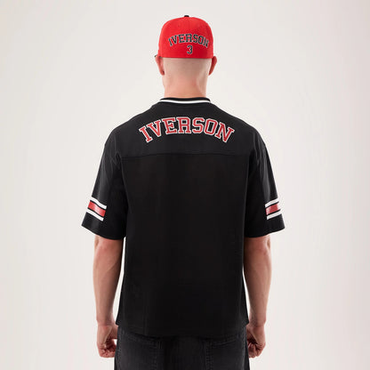 New Era Philadelphia 76ers NBA Hardwood Classic Mesh Oversized Black T-Shirt, back view on a model wearing a red cap, showing Iverson lettering in red and white across the upper back, and distinct red and white stripes on the sleeves.
