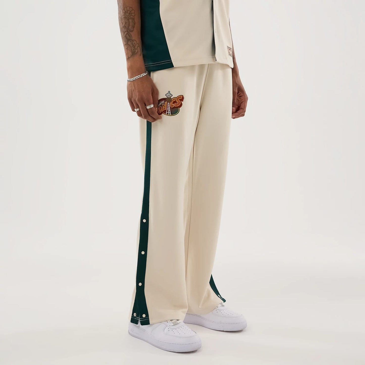 The model is wearing this NBA Hardwood Classic Straight Seattle Supersonics Straight Leg Joggers in light beige. 6