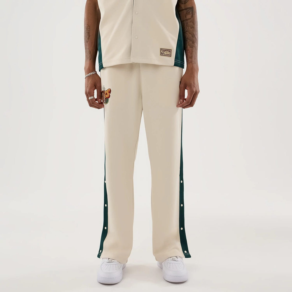 The model is wearing this NBA Hardwood Classic Straight Seattle Supersonics Straight Leg Joggers in light beige. 1