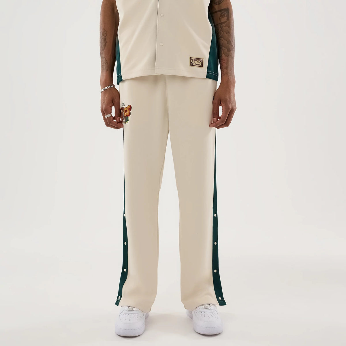 The model is wearing this NBA Hardwood Classic Straight Seattle Supersonics Straight Leg Joggers in light beige. 1