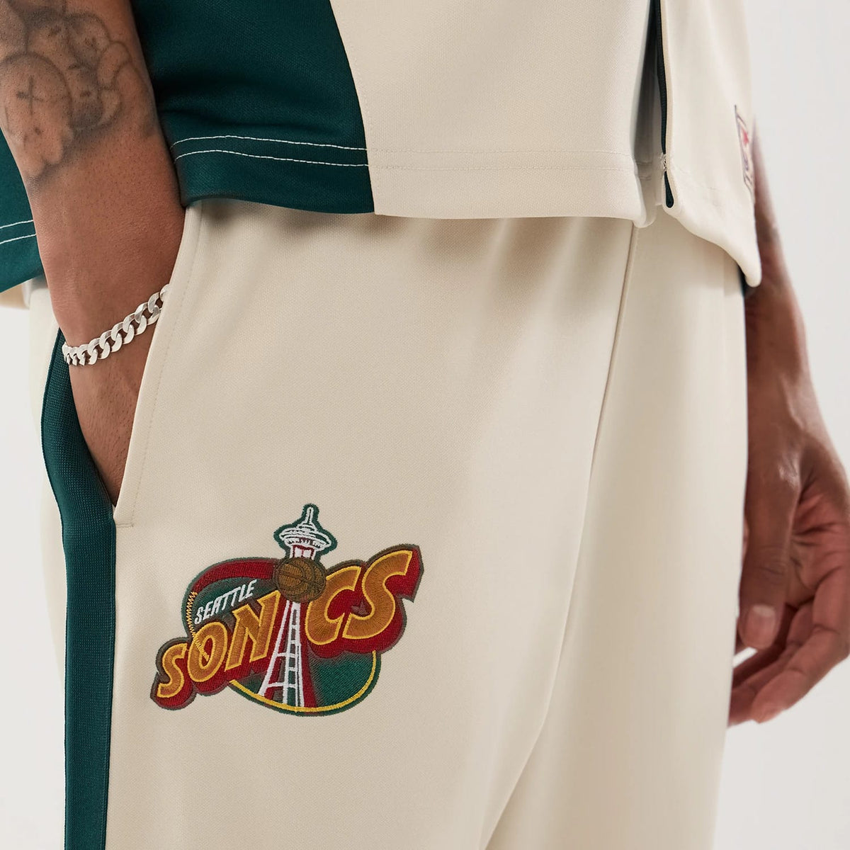 The model is wearing this NBA Hardwood Classic Straight Seattle Supersonics Straight Leg Joggers in light beige. 3